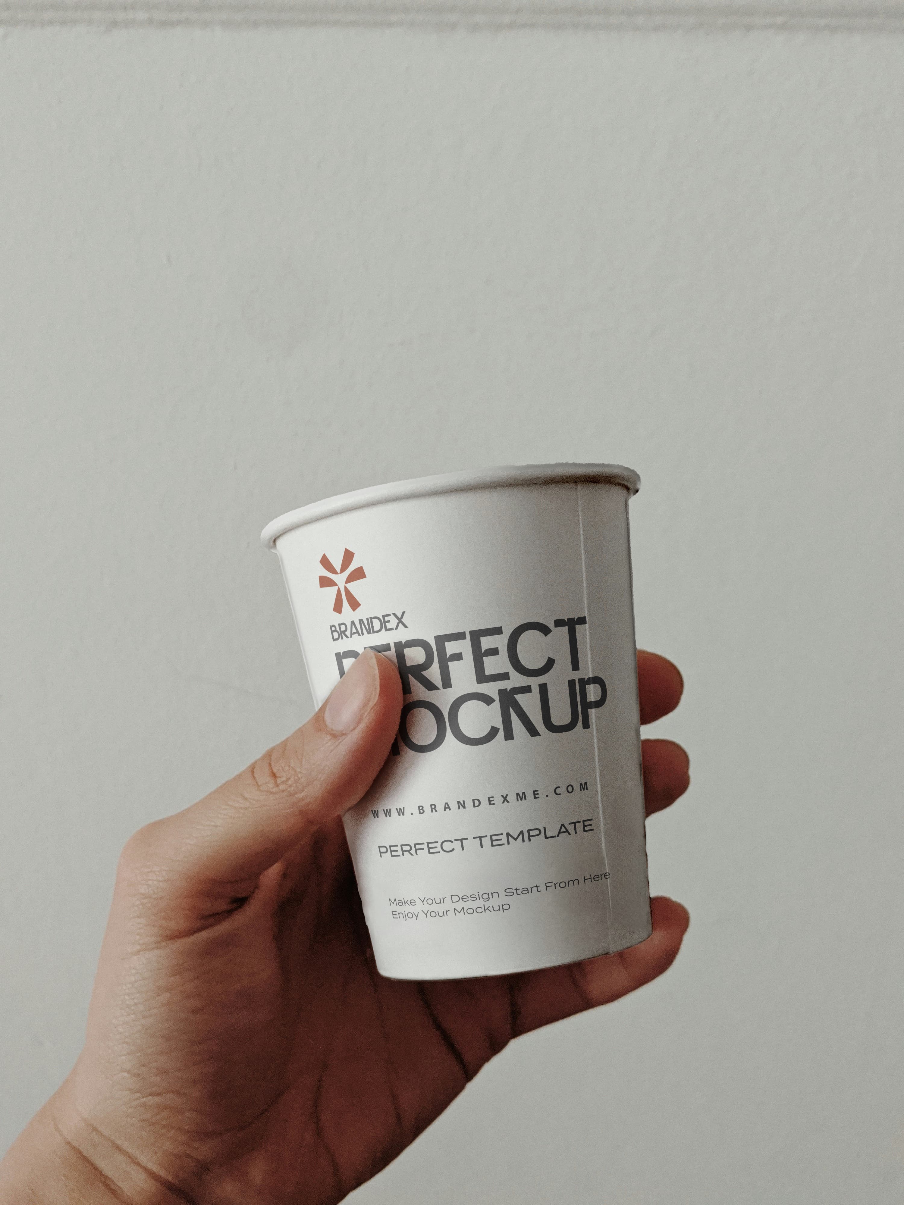 Handheld white paper cup mockup