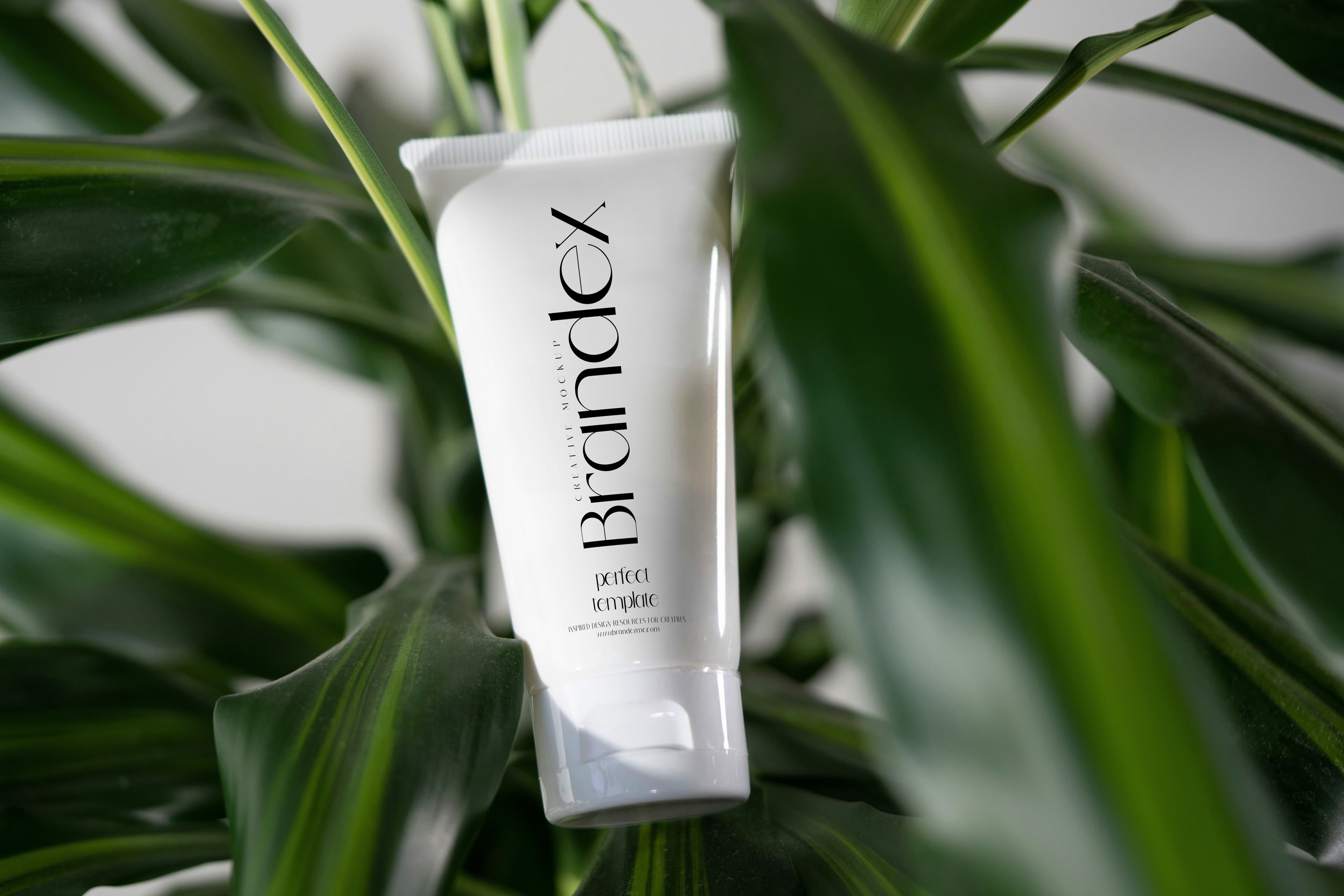 White skincare tube with plants mockup