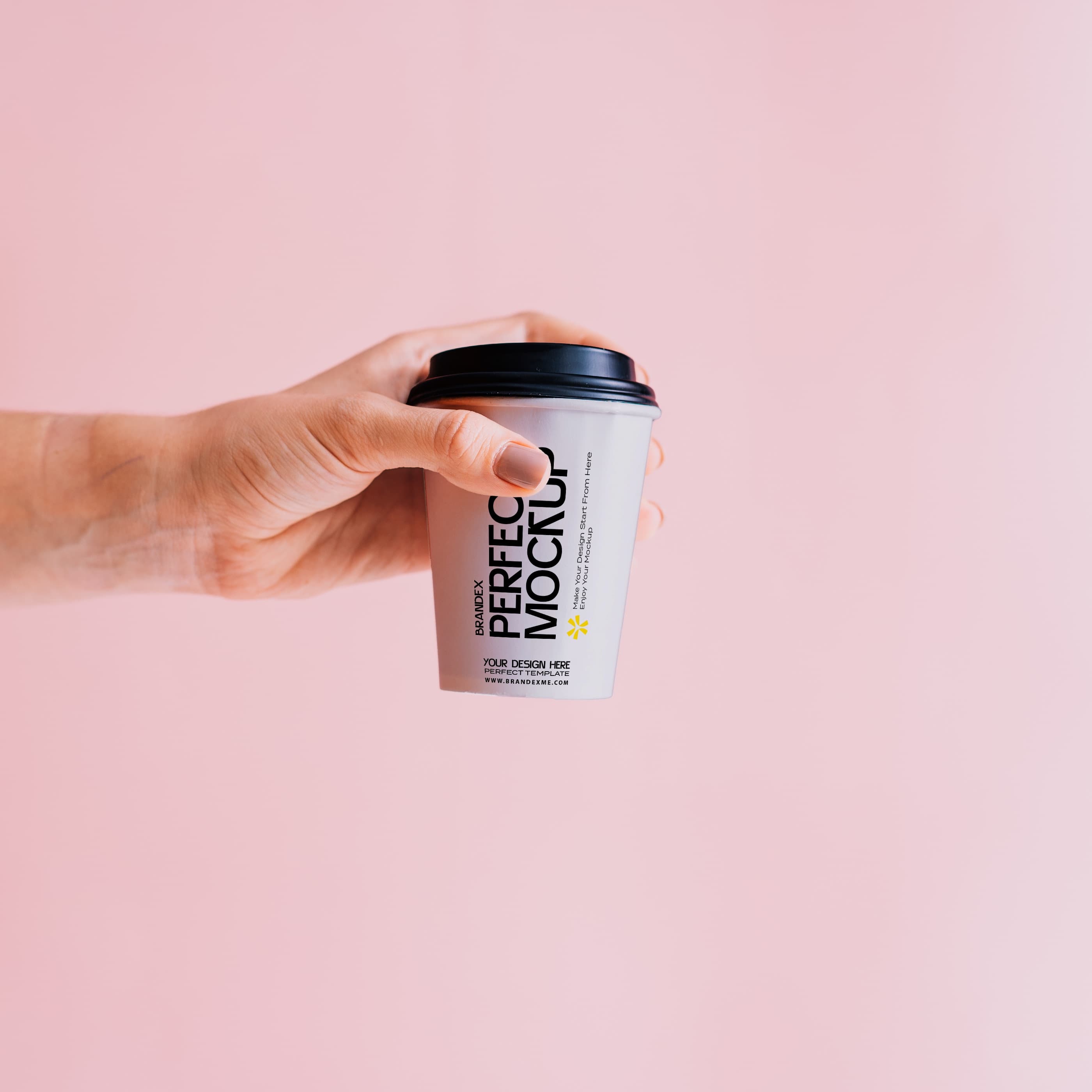 Hand Holding White Paper Coffee Cup Mockup on Pink Background